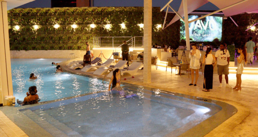 Skyline and seating area: Elegant rooftop seating with city lights in the background at Ramee Grand.