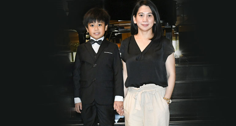 Young Filipino pianist smiling with his mother